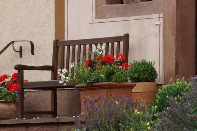 Blumenschmuck und Ruhebank vor einem Haus in Pfohlbach.
