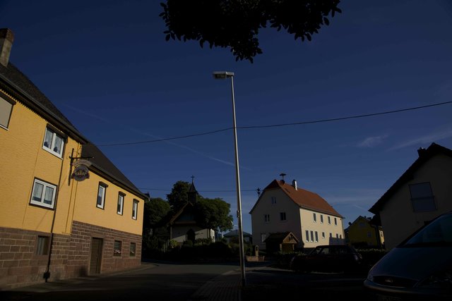Dorfgemeinschaftshaus  in Windischbuchen an einem Augustmorgen, im Vordergrund die Gaststätte "Hufeisen"