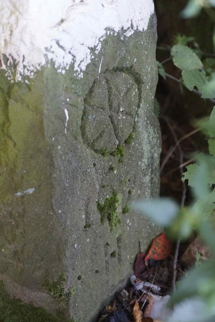 Grenzstein mit dem einstigen Herrschaftswappen, dem sechs-speichigen Mainzer Rad.
