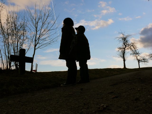Zwei Kinder bestaunen ein Steinkreuz im Odenwald. Gesehen bei Windischbuchen.