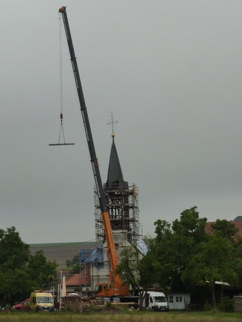 Stahlräger wird durch Turmdach gesteckt
