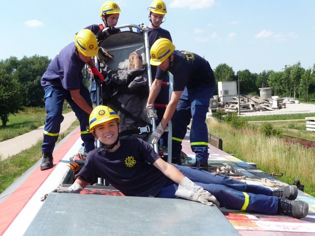 Andere mühen sich ab, einer macht Pause ... Rettung des Patienten aus dem umgekippten Eisenbahnwaggon.
