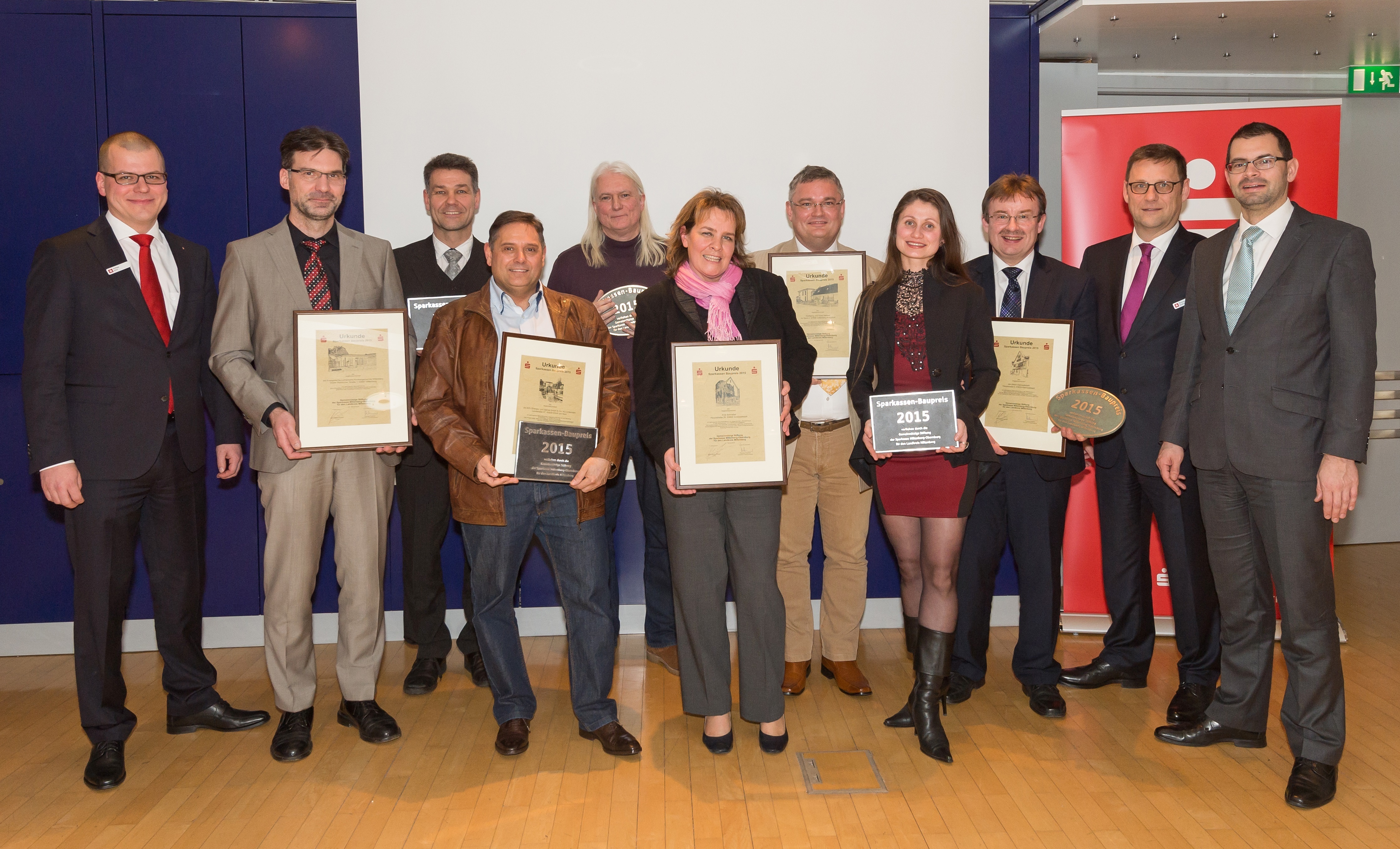 Baupreisverleihung der Sparkasse Miltenberg-Obernburg mit (von links) Philipp Ehni (Vorstandsmitglied Sparkasse), Markus Lorenz und Pfarrer Peter Neubert (Evangelisch-Lutherische Gemeinde Miltenberg), Norbert Berres (EZV Untermain), Axel und Anja Schnabel (Großwallstadt), Wolfgang und Iryna Weimer (Collenberg-Kirschfurt), Bürger-meister Thomas Köhler (Kleinwallstadt), Thomas Feußner (Vorstandsvorsitzender Spar-kasse) und Landrat Jens Marco Scherf.