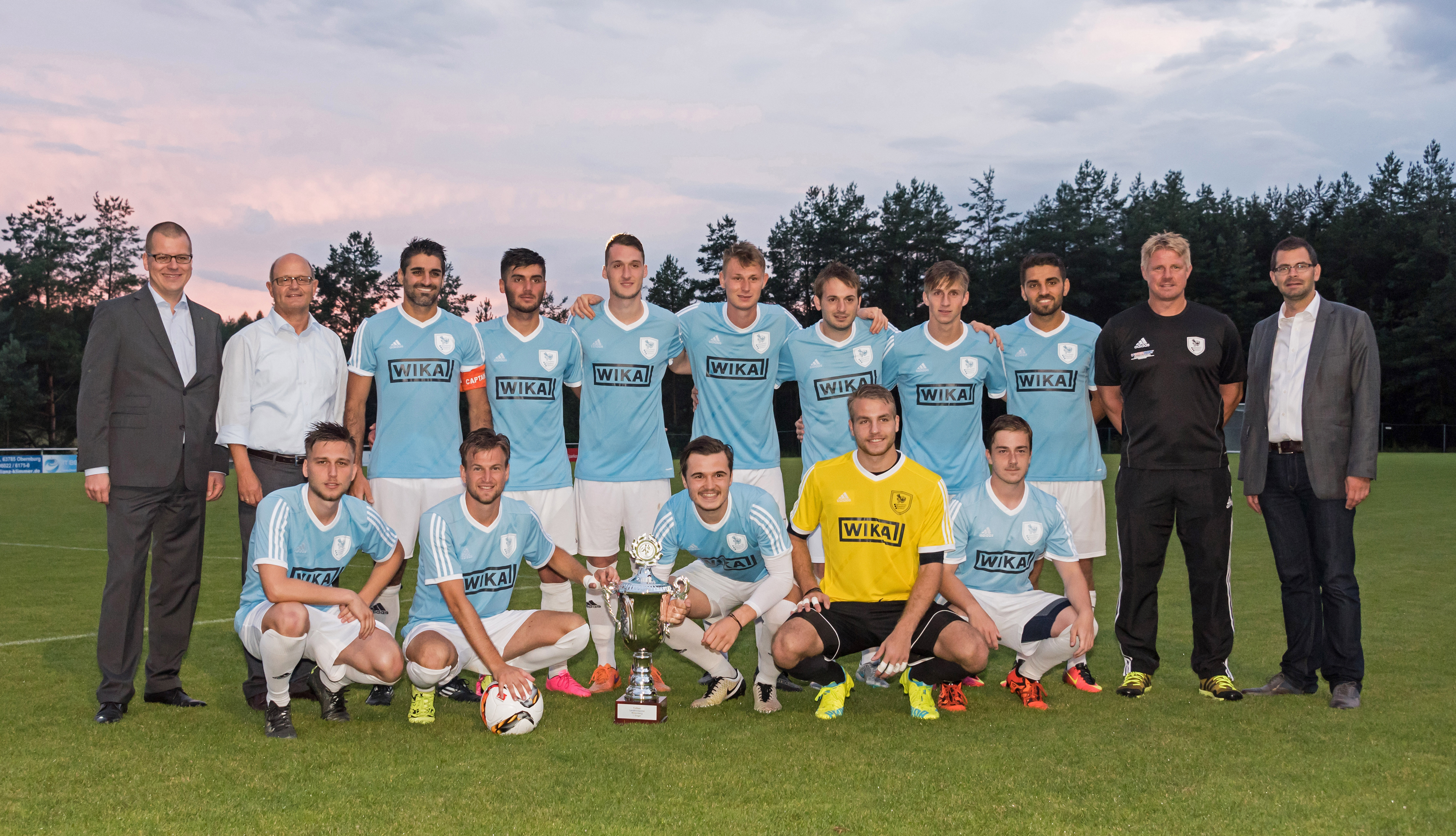Das Team des siegreichen SV Erlenbach mit Philipp Ehni (Sparkasse) und Bürgermeister Michael Berninger (hinten von links) sowie Landrat Jens Marco Scherf und Trainer Marco Roth (hinten von rechts).