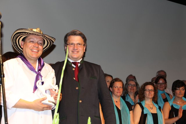 Staatsminister Prof. Dr. Winfried Bausback überreichte den Bayerischen Löwen für das beste Pflichtstück an Dirigent Mr. Rafeal Ángel Suescún Mario vom kolumbischen Chor.
