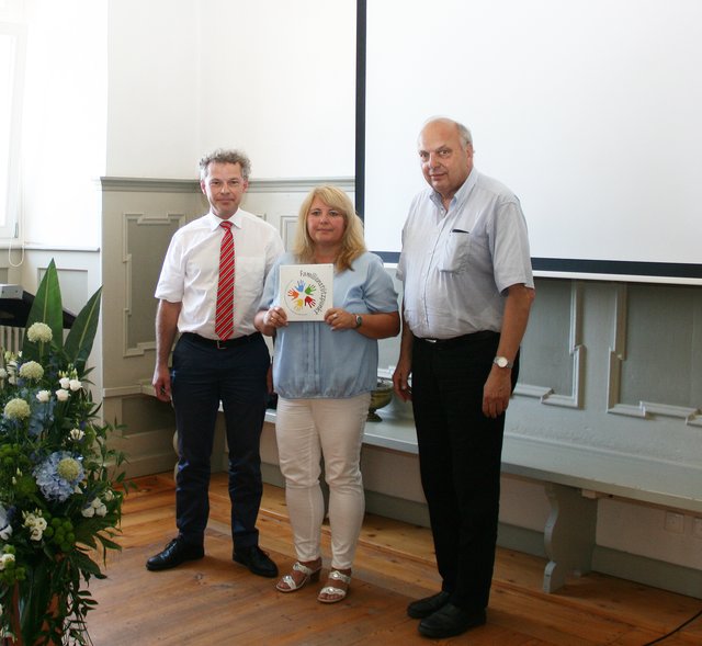 Übergabe des Schildes von Ministerialrat Robert Höcherl vom Sozialministerium an Inge Richter, Leiterin des Caritas-Familienstützpunktes und den Caritas-Kreisvorsitzenden Hans Dieter Arnold.