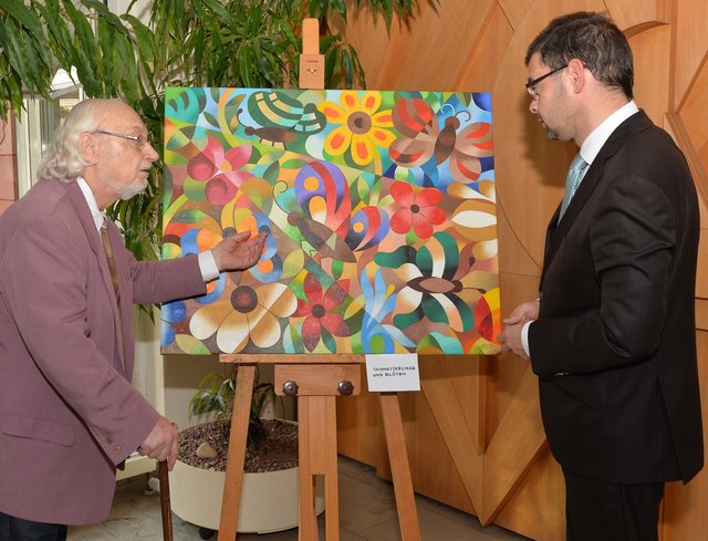 Horst Rother (links) mit Landrat Jens Marco Scherf vor seinem Lieblingsbild „Schmetterlinge und Blüten“.