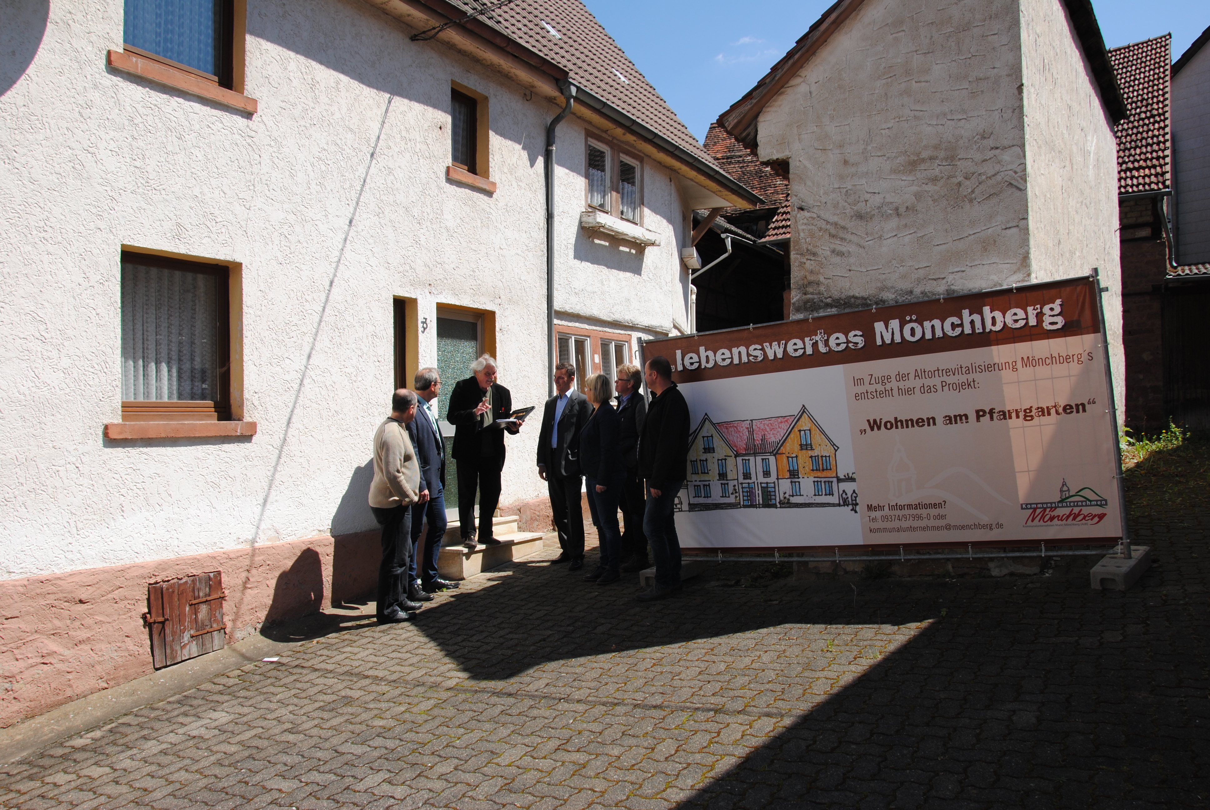 Andreas Hofmann (Verwaltungsrat), Bürgermeister Thomas Zöller (Verwaltungsratsvorsitzender), Stefan Brück (Vorstand Kommunalunternehmen), Daniela Schmitt (Marktgemeinderätin), Architekt Bertwin Kaufmann (Architekturbüro Kaufmann, Mönchberg) und Wolfgang Stanger (Verwaltungsrat) (v. l.) verfolgen die Ausführungen von Städteplaner Rainer Tropp (Büro HTWW, Aschaffenburg) (3. v. l.) zum Projekt „Wohnen am Pfarrgarten“.