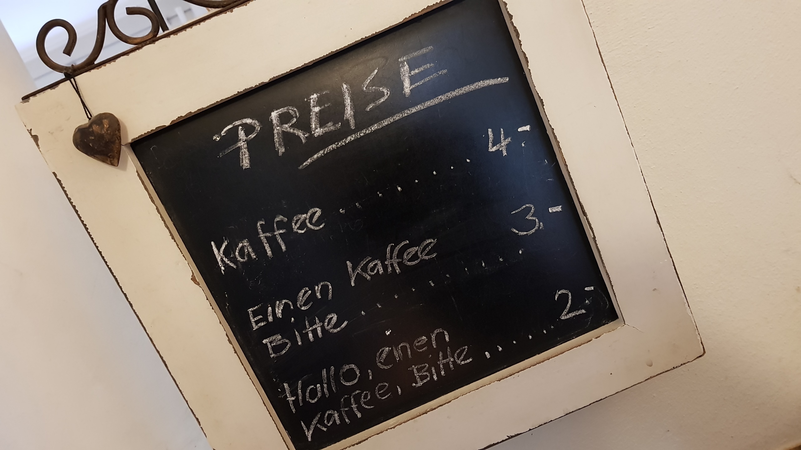 Höflichkeit zahlt sich hier im wahrsten Sinne aus: Preistafel in einem Café.