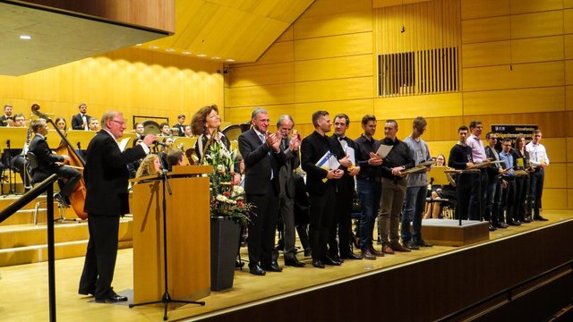 Einige der teilnehmenden Dirigenten zusammen mit (von links) Prof. Ernst Oestreicher, Juryvorsitzender Isabelle Ruf-Weber, MdB Paul Lehrieder und dem Präsidenten der Hochschule, Prof. Dr. Christoph Wünsch, vor dem Nordbayerischen Jugendblasorchester.