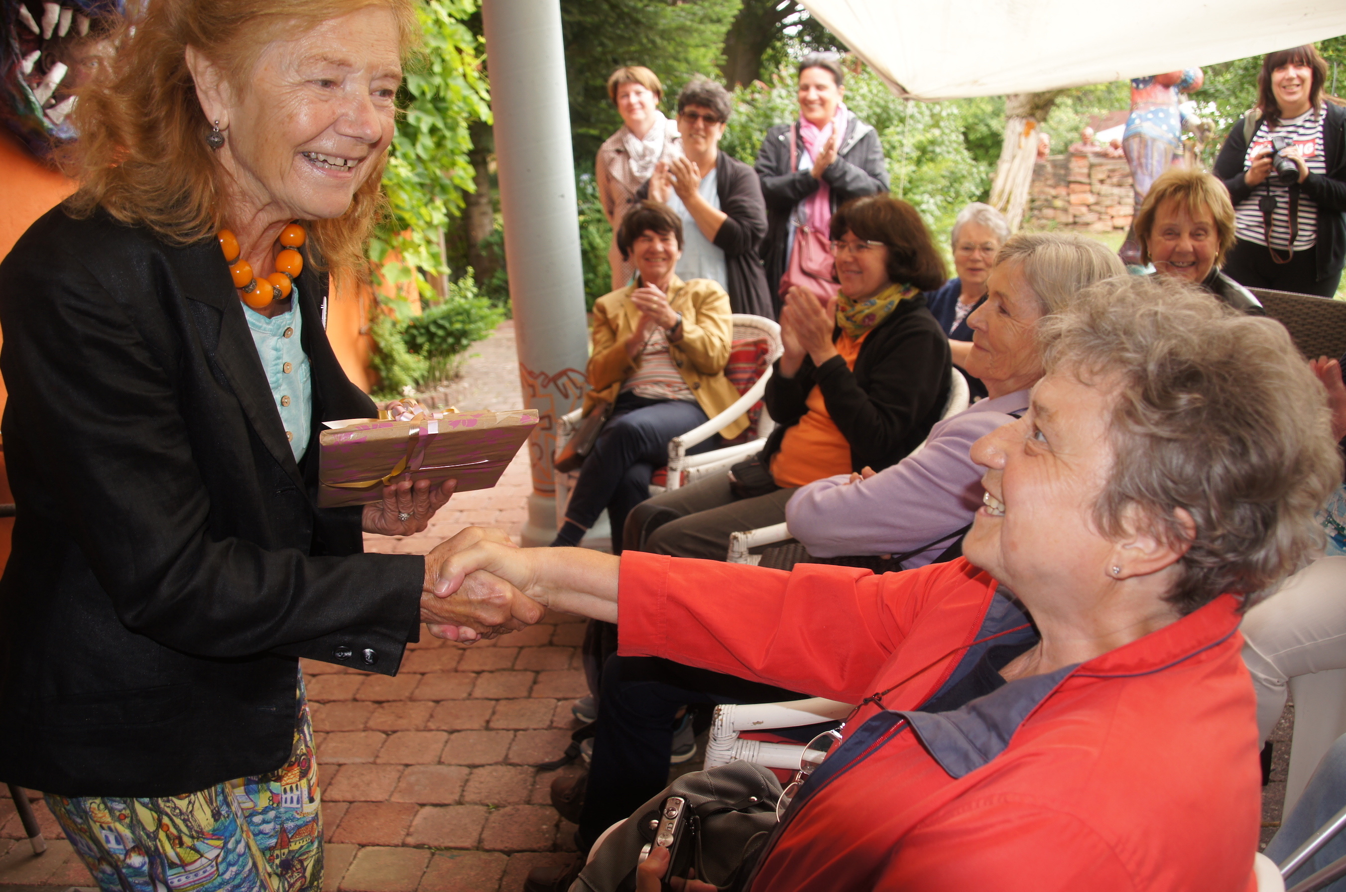 Als 900ste Besucherin der Führungen im Skulpturengarten erhält Annemarie Antl (rechts) vom Literaturkreis Hanau ein Geschenk von Karin Günther.