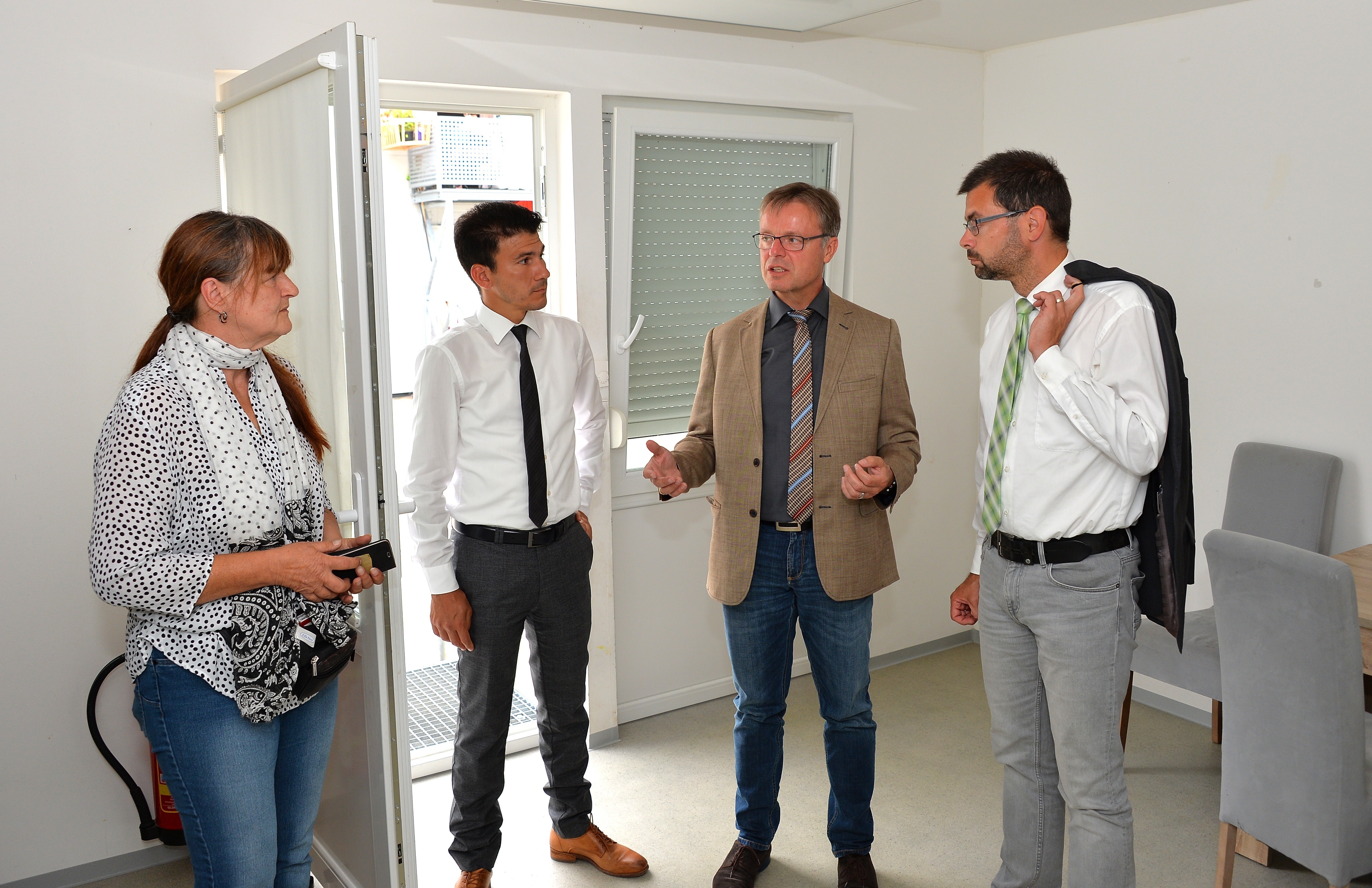 Dass es in den Containerwohnungen in der Gemeinschaftsunterkunft Obernburg recht eng ist und es im Sommer sehr warm werden kann, erfuhren Bürgermeister Dietmar Fieger (zweiter von rechts) und Landrat Jens Marco Scherf (rechts) von Petra Vonderheidt und Ronald Guzman.