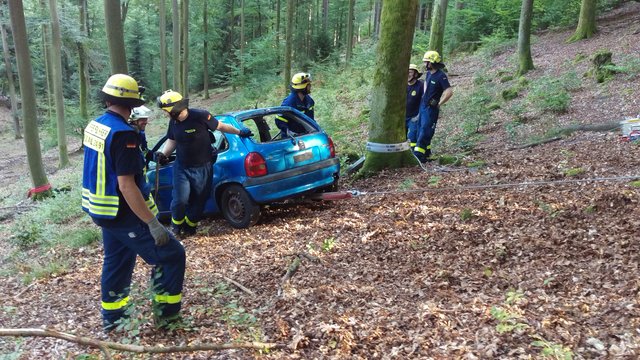 THW- und Feuerwehr-Helfer beim Bergen es abgestützten Fahrzeuges aus dem gut 95 Meter weit unten liegenden Tal.