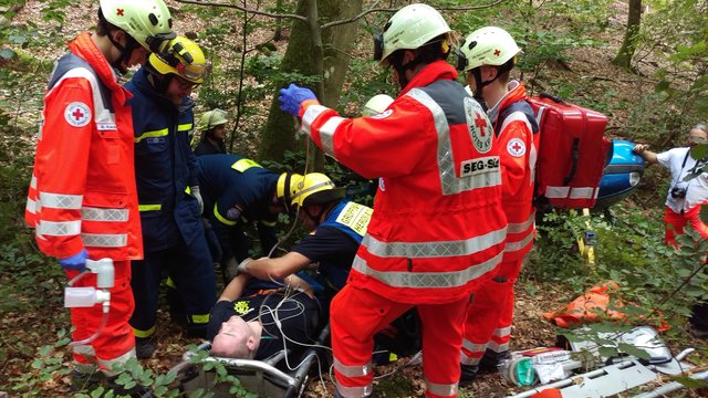 Die Einsatzkräfte beim Verlasten des Verletzten auf der Bergetrage.