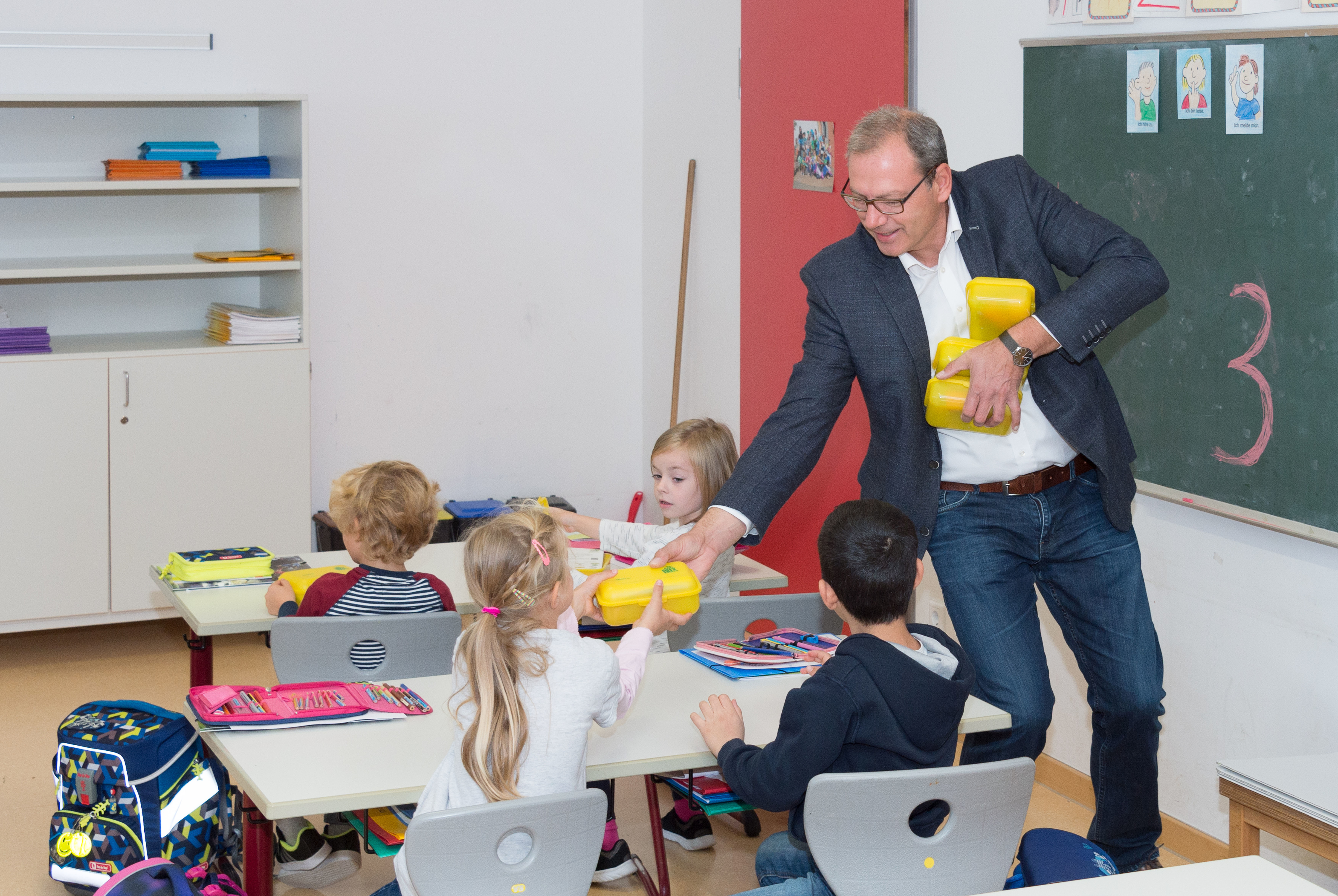 Alle 1200 Erstklässlerinnen und Erstklässler im Landkreis Miltenberg hat der Bund Naturschutz mit Bio-Brotboxen versorgt. Stellvertretender Landrat Thomas Zöller half dabei, den Mönchberger Kindern die Boxen zu überreichen.