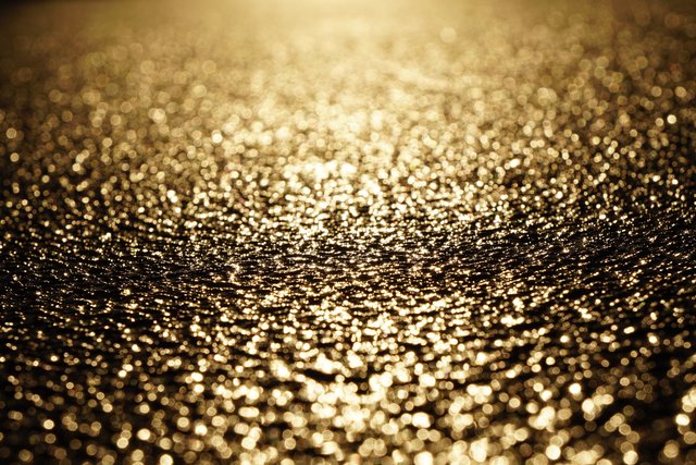 Glitzernde Regentropfen auf einem geteerten Weg im bayerischen Odenwald bei Miltenberg.