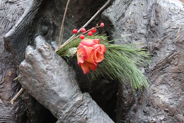 Pars pro toto: Blüten und Blumen-Präsent an einem Denkmal in Miltenberg am Marktplatz. 