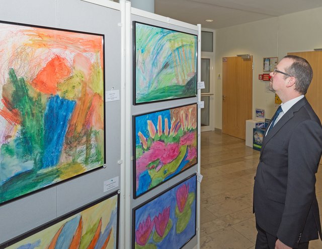 Ein Bild schöner als das andere: Stellvertretender Landrat Thorsten Meyerer freut sich über so viel tolle Kunstwerke der Kinder.