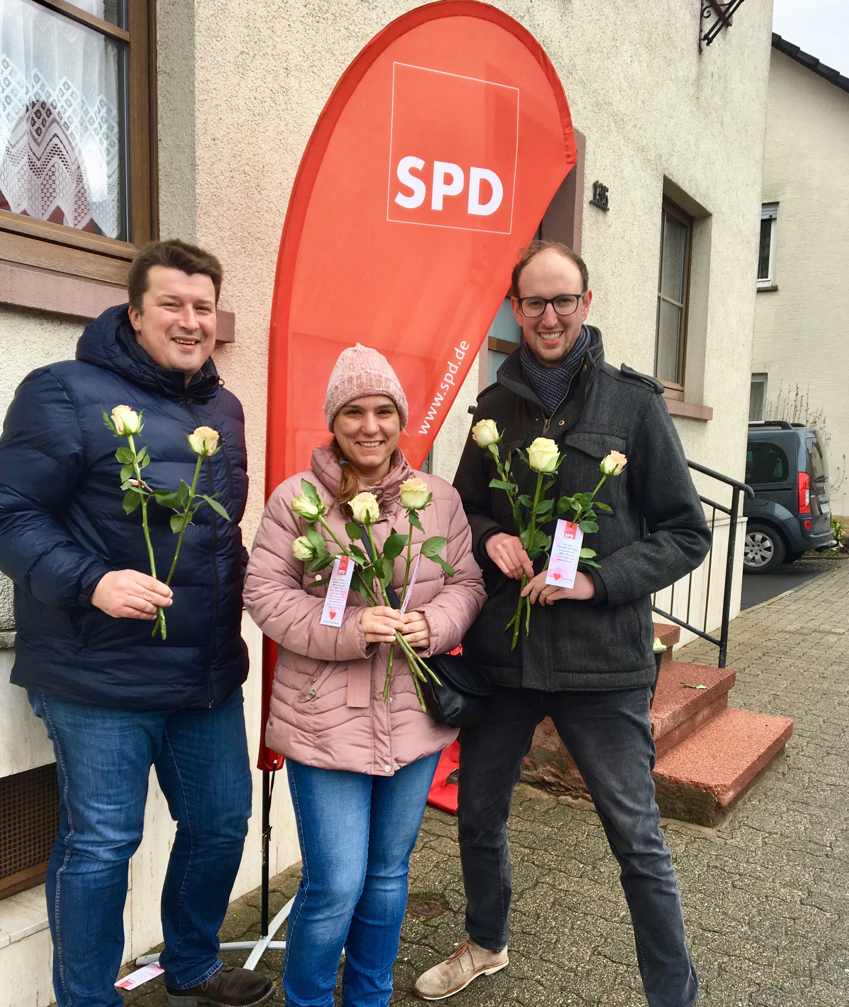 Axel Ebert, Marina Oliveira und Benjamin Bohlender verteilten vor der Bäckerei Weigl in Mechenhard Rosen zum Weltfrauentag.