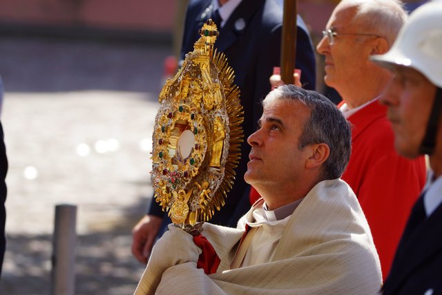Im Mittelpunkt steht die geweihte Hostie in der Monstranz, die vom Pfarrer von Station zu Station getragen wird und bedeutet:   Christus ist unter uns - im Alltag und bei Festen, im Beruf und in der Freizeit, in allen Lebensbereichen bei allen Menschen. 