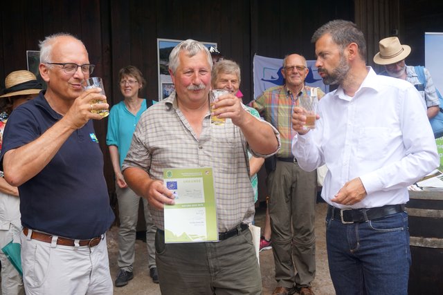 Mit einem kräftigen Schluck Moscht wird auf die Verleihung der Pro-Natura2000-Urkunde angestoßen: von links Jörg Steinhoff, verantwortlich fürs Sachgebiet Naturschutz bei der Regierung von Unterfranken, Landwirt Michael Breunig und Landrat Jens Marco Scherf.
