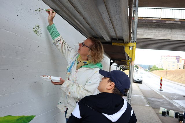 Sorgfältige Tupfenarbeit am Wandbild in der Erlenbacher Unterführung. 