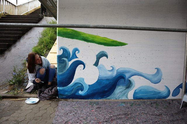 Schüler/innen der Mittelschule Erlenbach arbeiten das Wandbild farblich aus. 