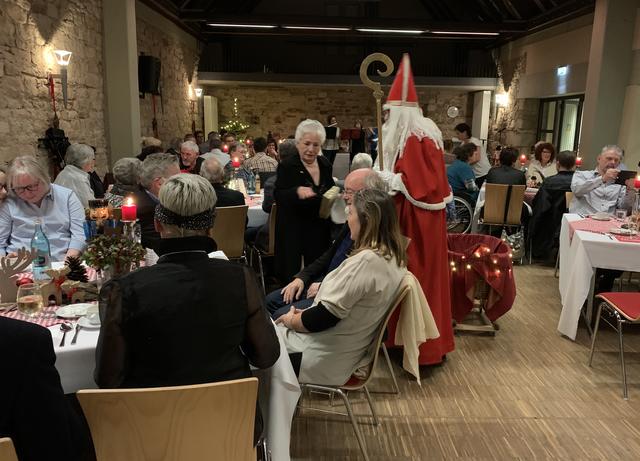 Bei der Weihnachtsfeier verteilt der Nikolaus Geschenke.