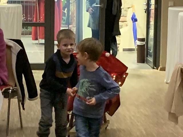 Theo und Emil ziehen den Wagen mit den Geschenken, die der Nikolaus verteilt.