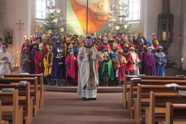Die Sternsinger mit Pfarrer Kölbel beim Singen ihres Liedes "Wir kommen daher aus dem Morgenland" | Foto: Martin Winkler