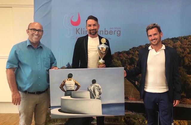 Der 1. Preis geht an Andreas Küpper (Mitte), Links neben ihm Bürgermeister Ralf Reichwein, rechts der Schauspieler Johann Rosenhammer.