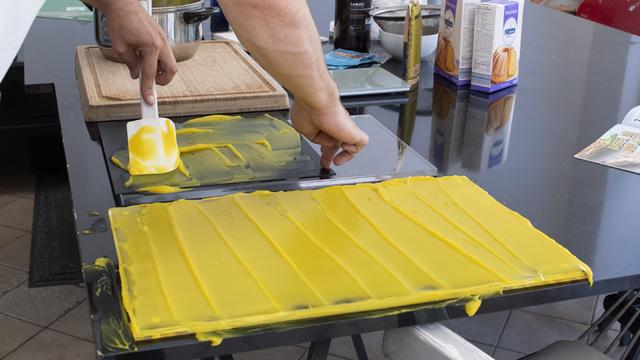 Bioplastikmasse wird auf einer glatten Oberfläche aufgetragen und härtet aus. Zum Wettbewerb „Mein(e) Plastik ist bio!“ kann die (Bio-)folie anschließend weiterverwendet werden. | Foto: BMBF/Wissenschaftsjahr