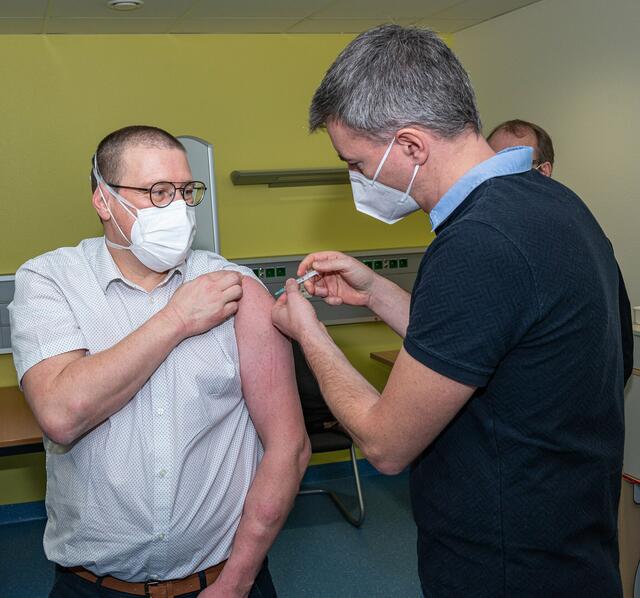 Sie gehen mit gutem Beispiel voran: Dr. Frank Ziegler (links, Chefarzt der Anästhesie und Intensivmedizin an der Helios Klinik Erlenbach) lässt sich von Dr. Michael Weberpals (Pandemiebeauftragter und Chefarzt der Kardiologie der Klinik) den Coronavirus-Impfstoff verabreichen. Beide Ärzte wollen damit ein Vorbild für möglichst viele Menschen sein, sich ebenfalls impfen zu lassen. | Foto: Landratsamt Miltenberg