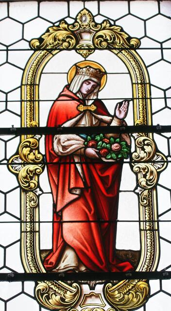 Das „Rosenwunder“ ist die wohl bekannteste Legende über die heilige Elisabeth. Sie verwirklichte konsequent den von ihr aufgestellten Kanon der sieben Werke der Barmherzigkeit. - Fensterglasbild in der katholischen Pfarrkirche von Eichenbühl-Heppdiel im Landkreis Miltenberg. 