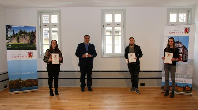 Bürgermeister Thomas Münig (2. v. links) gratuliert den erfolgreichen Auszubildenden Valeria Simitsch, Leon Grimm und Nicole Helwer (v. l. n. r.) zu ihren hervorragenden Abschlüssen.