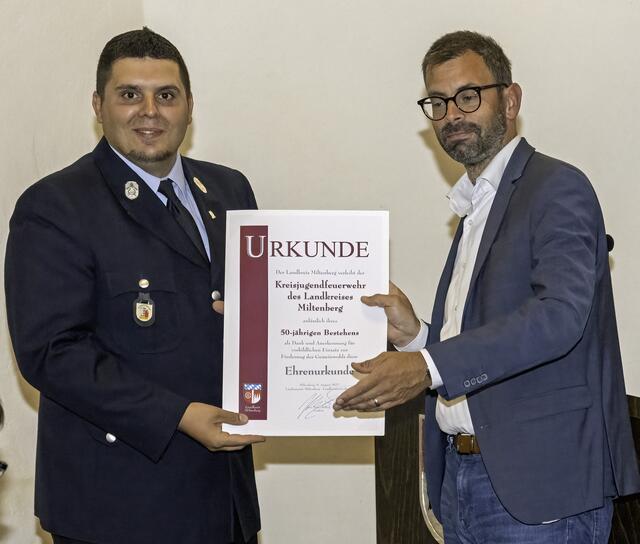 Landrat Jens Marco Scherf (rechts) überreichte zum 50-jährigen Bestehen des Kreisjugendfeuerwehrverbands eine Urkunde an Kreisjugendfeuerwehrwart Joao Pedro Lopes Meira. | Foto: Winfried Zang