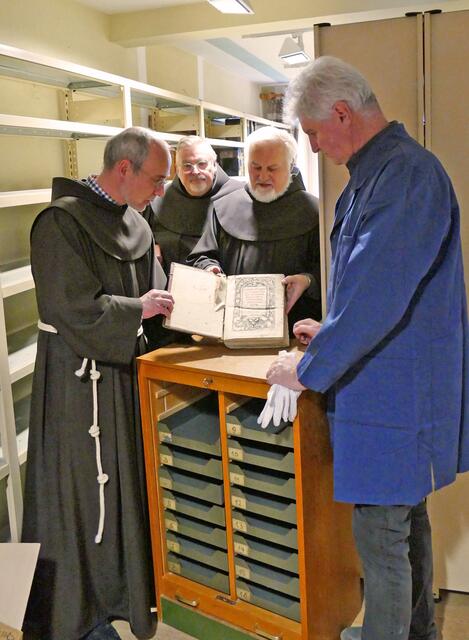 Pater Damian (links) erklärt seinen Mitpatres und Hermann Neubert, dem Vertreter des Miltenberger Archivs, eine weitere wertvolle Handschrift
