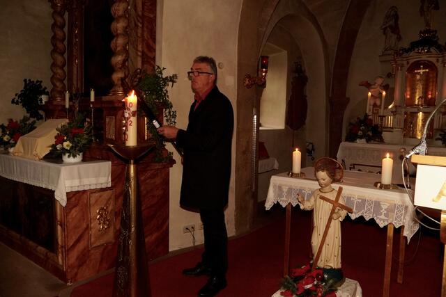 Kirchenpfleger Willi Schlegel in Eichenbühl-Heppdiel  beim Anzünden der Kerzen. 