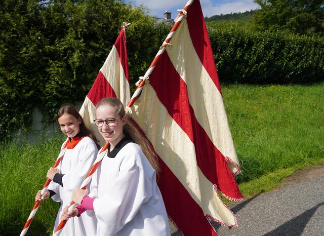 Johanna Kuhn (rechts) und Emilia Gesele (links):
„Wir sind in unserer Pfarrei gerne Ministrantinnen. Am heutigen Sonntag dürfen wir mit Fahnen die Bittprozession der Eichenbühler zum St.-Josefs-Bildstock begleiten. Mit dabei sind viele Gläubige, die Blasmusik, der Pfarrer, ein Vorbeter und unser Bürgermeister. Danach ministrieren wir zusammen mit anderen Mädchen und Jungen in der Pfarrkirche. Das Erleben von Gemeinschaft macht uns allen viel Spaß.“
