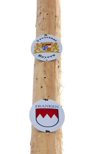 Franken und Bayern auf Schildern am neuen Maibaum in Heppdiel. 