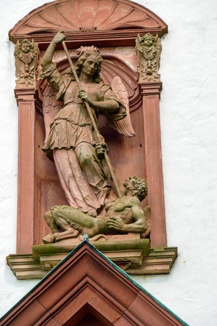 Die Statue des Heiligen Michael, der den Bösen besiegt, in einer Nische im Giebelfeld