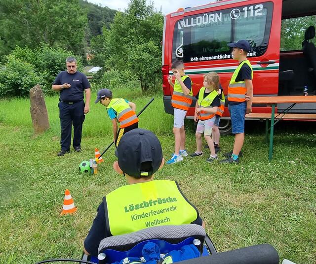 Die „Löschfrösche“ der Kinderfeuerwehr Weilbach kehren nacheinander mit einem Besen einen Ball durch einen Slalom aus Verkehrsleitkegeln. | Foto: privat