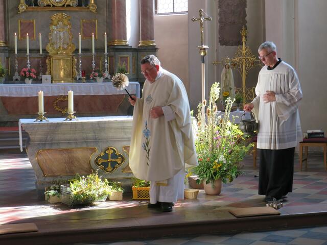Pfarrer Toni Wolf segnet die Kräuterbüschel mit Weihwasser | Foto: Nina Reuling