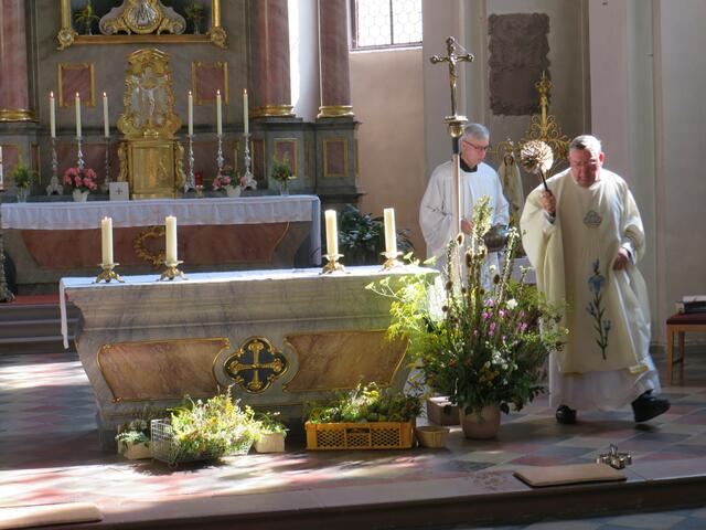 Pfarrer Toni Wolf segnet die Kräuterbüschel mit Weihwasser | Foto: Nina Reuling