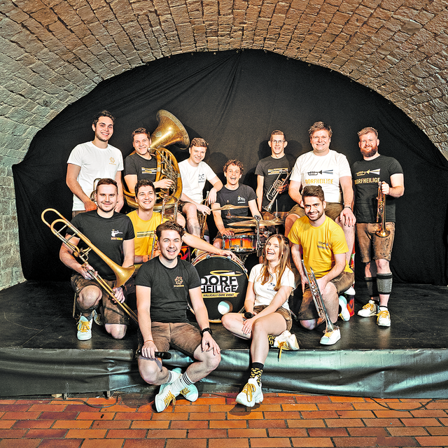 DORFHEILIGE - „Halligalli ohne Ende“ aus dem Unterallgäu!
Jung, wild und dynamisch zeigen euch die 12 Musiker, wie viel Power in Blasmusik steckt. Mit ihrem Programm sorgen sie für NON-STOP Stimmung: von Festzelt-Essentials, Evergreens und Schlagern bis hin zu aktuellem Pop, Rock und Partyhits. Da zieht es alle Partywilligen im Publikum unweigerlich auf die Bierbänke und Tanzflächen dieser Welt.
 | Foto: DORFHEILIGE