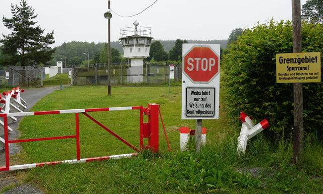 Klein-Berlin: Mödlareuth in Oberfranken.

"Klein-Berlin" im bayerischen Mödlareuth nahe der Grenze zur einstigen DDR. - Mitten durch Mödlareuth verlief lange Zeit eine Grenze. Ein Stück davon gehört heute zu einem Museum und steht immer noch.

Der Grund dafür: Nach dem Zweiten Weltkrieg wurde Deutschland geteilt. Im Osten entstand die Deutsche Demokratische Republik, kurz DDR, und im Westen die Bundesrepublik Deutschland. Mödlareuth lag genau auf der Grenze zwischen diesen beiden Staaten.

Weil viele Leute in der DDR mit der Politik unzufrieden waren und weg wollten, baute die Regierung ab 1961 Mauern, Zäune und Wachtürme entlang der Grenze. So war eine Flucht in den Westen fast unmöglich. In Mödlareuth zog sich diese Grenze mitten durchs Dorf.

Seit dem 3. Oktober 1990 gehören die beiden deutschen Staaten aber wieder offziell zusammen. Inzwischen ist das Datum deshalb auch ein Feiertag für alle. Er heißt Tag der deutschen Einheit. In Mödlareuth wird er jedes Jahr groß gefeiert.
