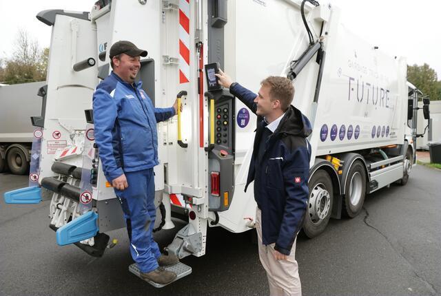 FAUN-Techniker Baldur Buchta erläutert Werkstattmitarbeiter Manuel Müssig die verschiedenen Funktionen der Schüttung im Heckbereich des Fahrzeuges. Besonderheiten sind die beleuchteten Griffe, das Handschuhwärmfach und der Monitor mit "Sicht vor den LKW"             Foto: Martin Hahn 
