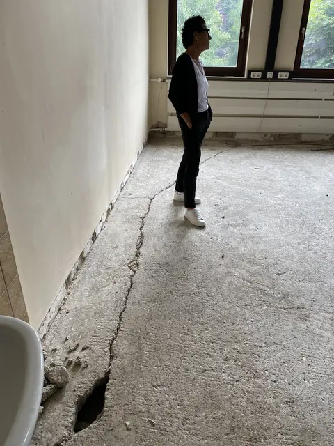 Ein tiefer Riss zieht sich einmal komplett ringsum an der Wand durch den Boden dieses Klassenzimmers. Helga Raab-Wasse, Mitglied im Bauausschuss, betrachtet den Zustand mit Sorge.  | Foto: Sabine Balleier