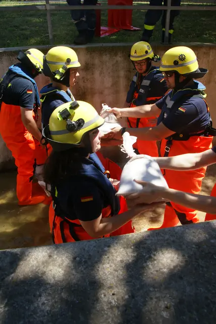 Unter realistischen Bedingungen üben die Einsatzkräfte das schnelle Verlegen von Sandsackbarrieren bzw. Mobilen-Barriere-Elementen, um das Wasser zu kanalisieren. | Foto: THW Miltenberg 