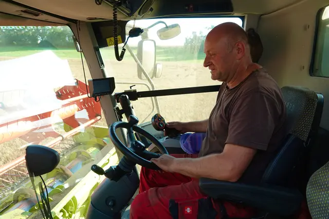 
 Mähdrescherfahrer Christoph Zeller aus Beuchen im Odenwald ist stundenlang im Einsatz. Funk-Kontakt gibt es mit Kollegen in Traktoren auf dem Getreidefeld und zum Silo einige Kilometer weiter: Die Zeit drängt. Der nächste Regen ist im Anmarsch. Foto Roland Schönmüller.